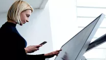 Woman using a phone and digital sign