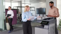 Colleagues talking at office printer