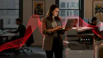 Woman typing on a laptop next to a Sharp MFP 