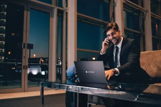 Businessman using laptop on phone at night