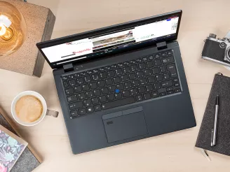 A laptop with a coffee next to it