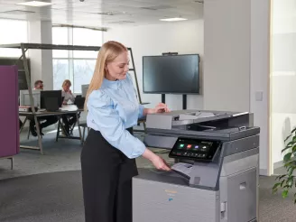 Female using a printer in an open office space
