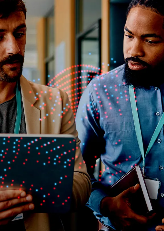 Two men talking whilst looking at a tablet 