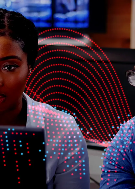 Man and woman both looking at a computer monitor